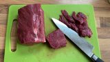 Rindfleisch in dünne, mundgerechte Streifen schneiden